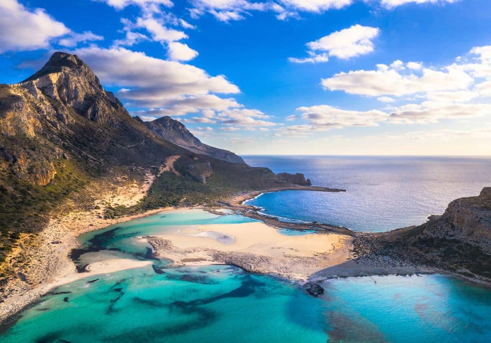 Beach-level shot: "Balos Beach Crete with pale sand and shallow turquoise lagoon water