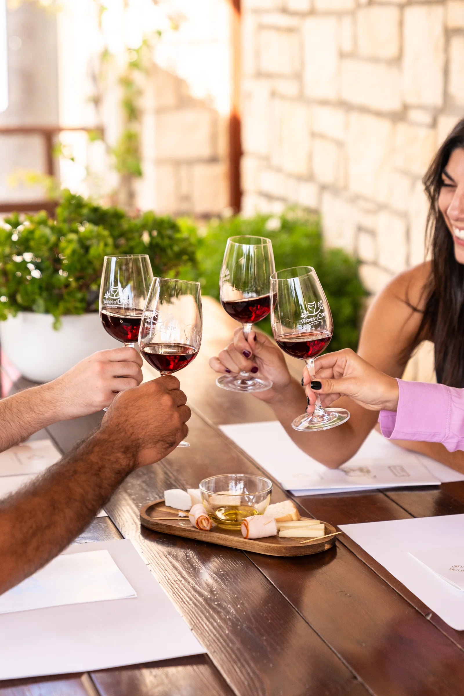 Glasses of red wine lined up on a wooden tasting table