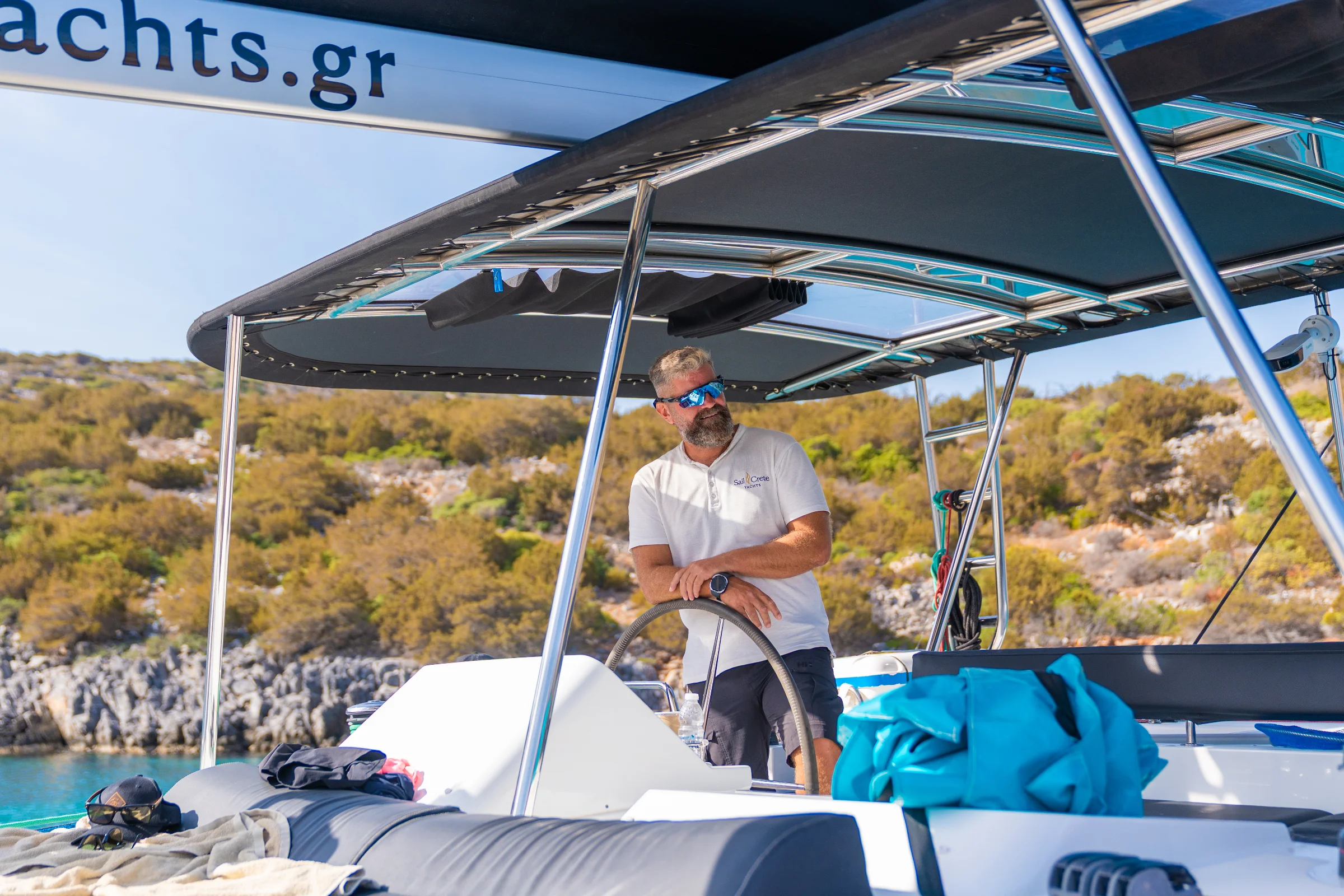 Wide shaded deck of a catamaran with sunbeds during a full-day cruise in Crete