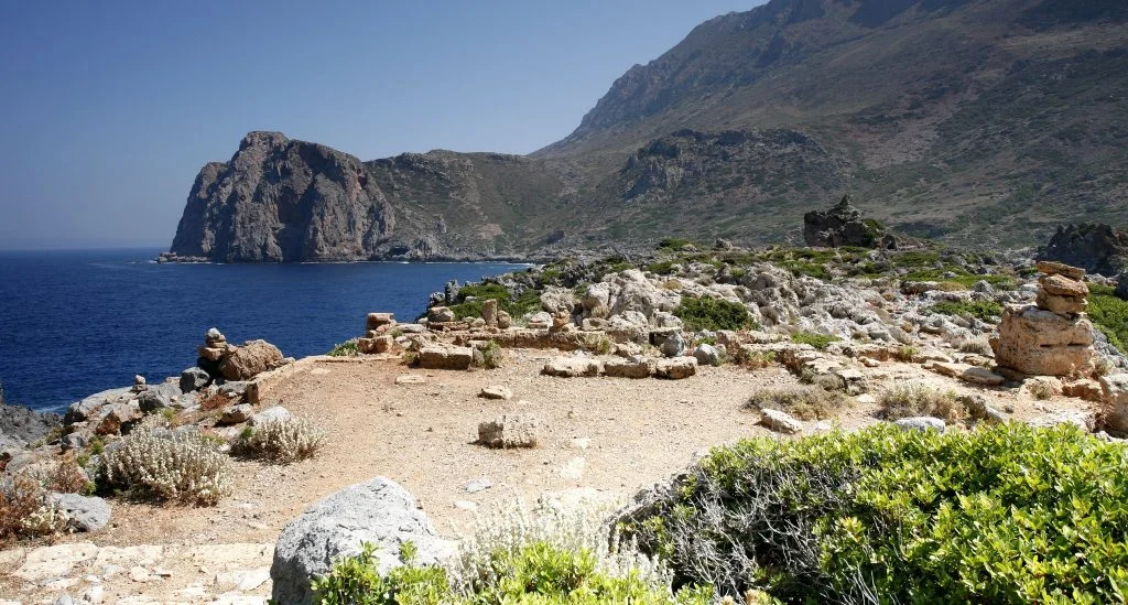 Rock-cut throne at the ancient city of Falassarna with the coastline in the background