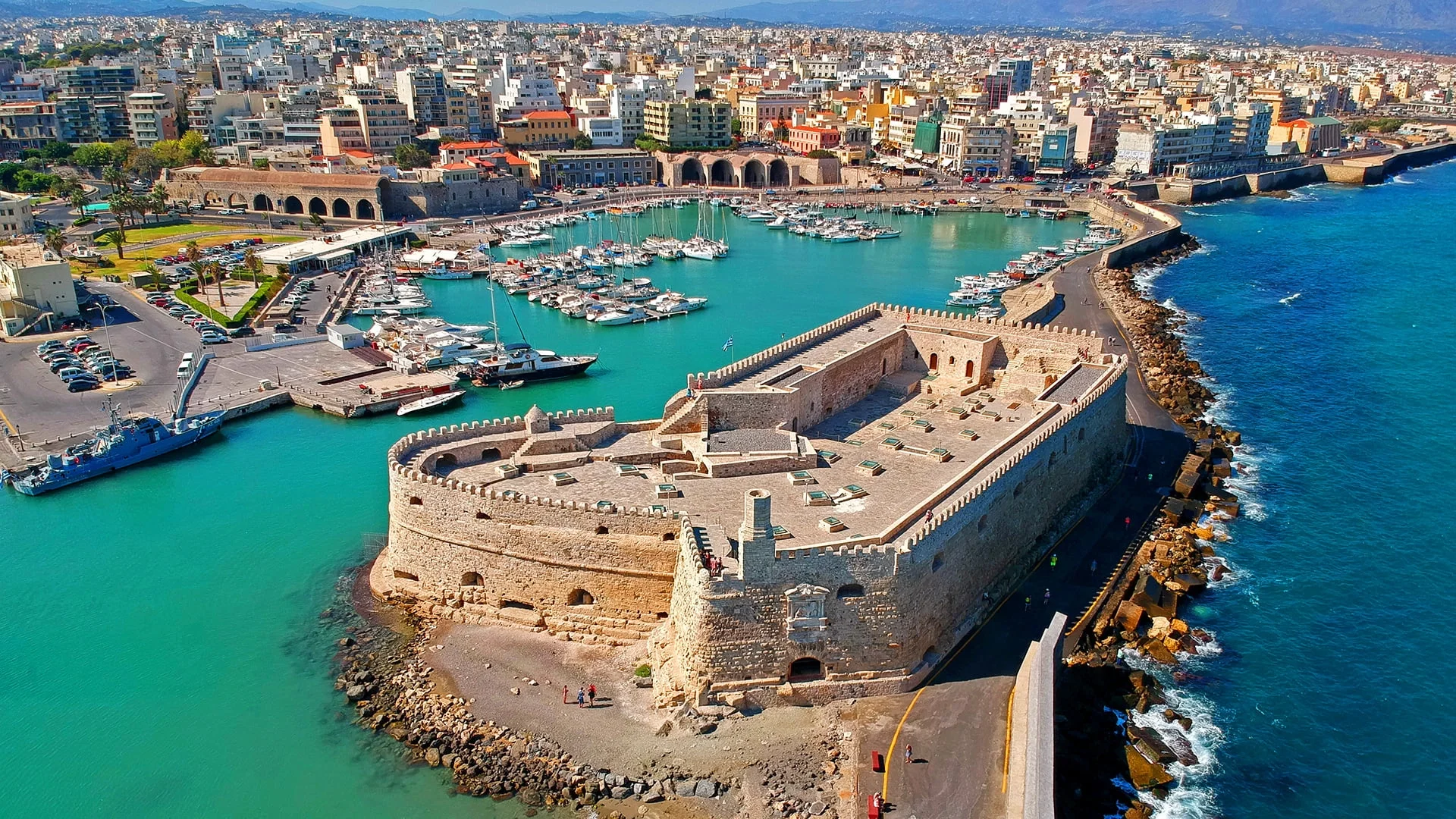 Koules Fortress at the entrance of Heraklion's Venetian harbour, viewed from the waterfront promenade with boats in the foreg