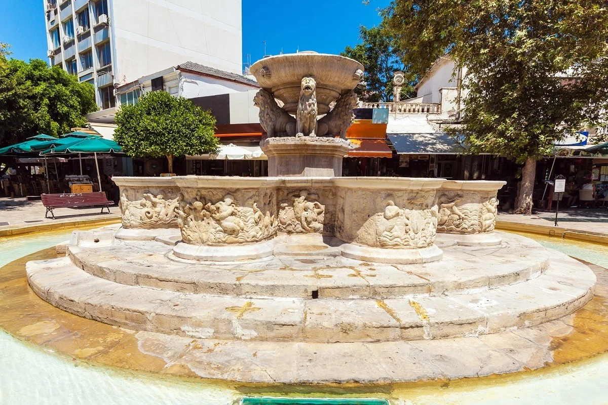 Morosini Fountain in Lions Square with the four lion heads visible and Heraklion's old town around it