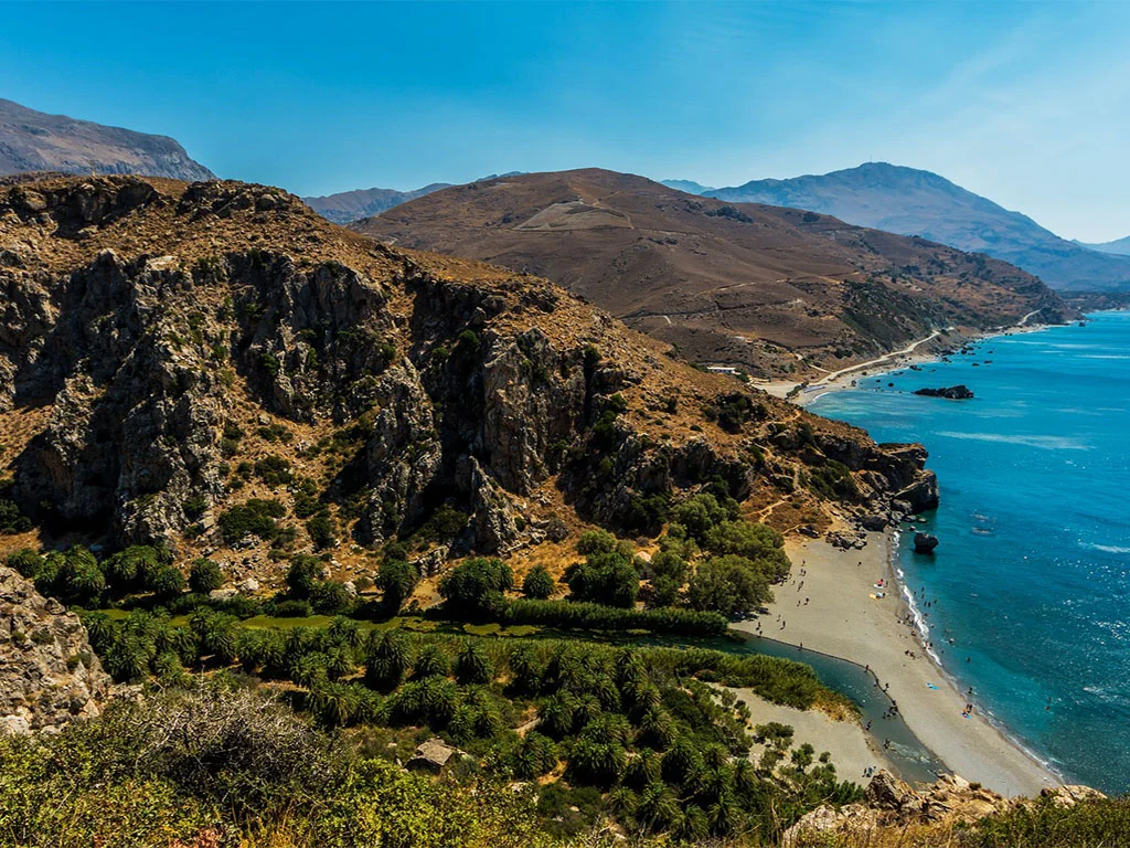 Preveli Palm Forest path through the Phoenix theophrasti grove with river visible and sea beyond]