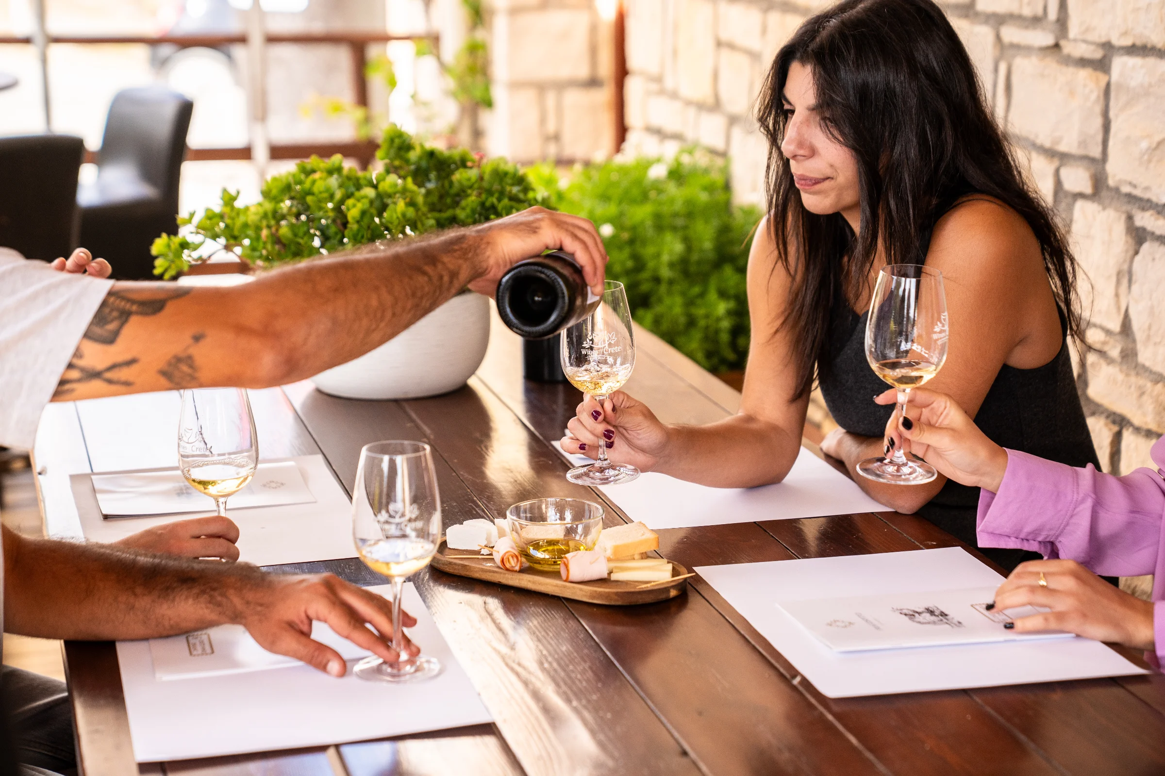 Glasses of Vidiano white wine on a wooden table at a winery tasting room, Heraklion, Crete